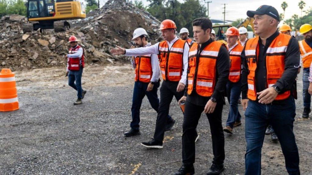 Samuel García, Gobernador de Nuevo León junto a arquitectos y trabajadores de construcción usando uniforme color naranja fosforescente supervisando obra pública para el Mundial del 2026