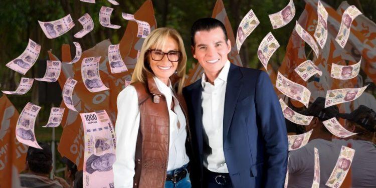 Smiling couple posing as paper money rains down around them at an outdoor event.