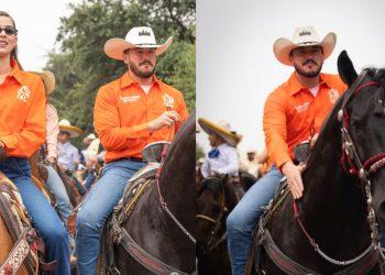 Two riders in orange Western shirts on horseback at a crowded outdoor rodeo or parade, with spectators in the background.
