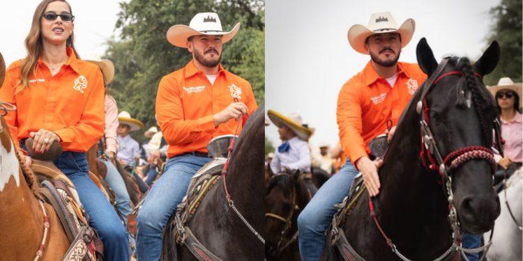 Two riders in orange Western shirts on horseback at a crowded outdoor rodeo or parade, with spectators in the background.